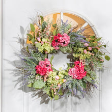 Load image into Gallery viewer, Floral wreath on a white door with wooden background