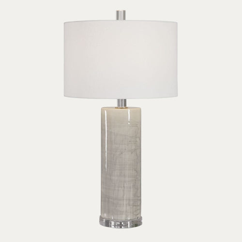 Table lamp with a white shade and textured cylindrical base on a white background