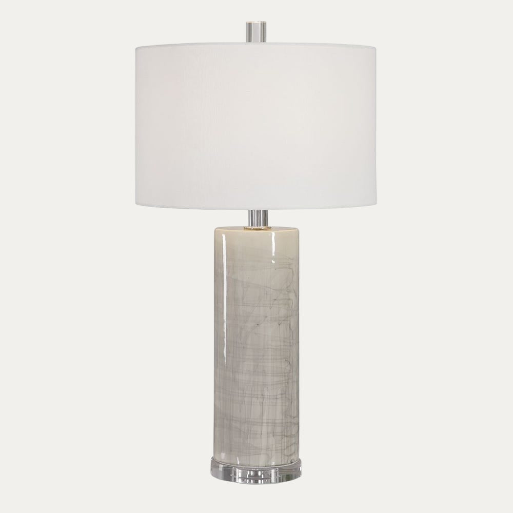 Table lamp with a white shade and textured cylindrical base on a white background