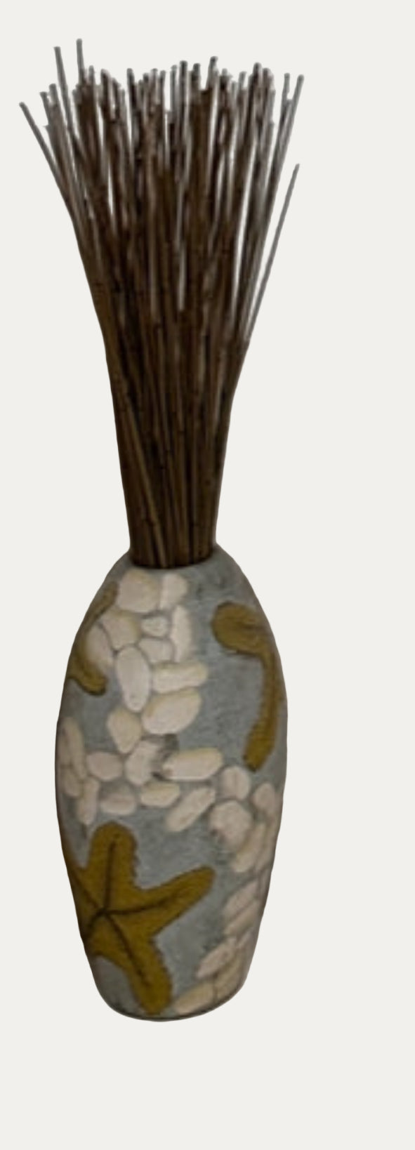 Decorative vase with pebbles and starfish design on a tiled bathroom wall.