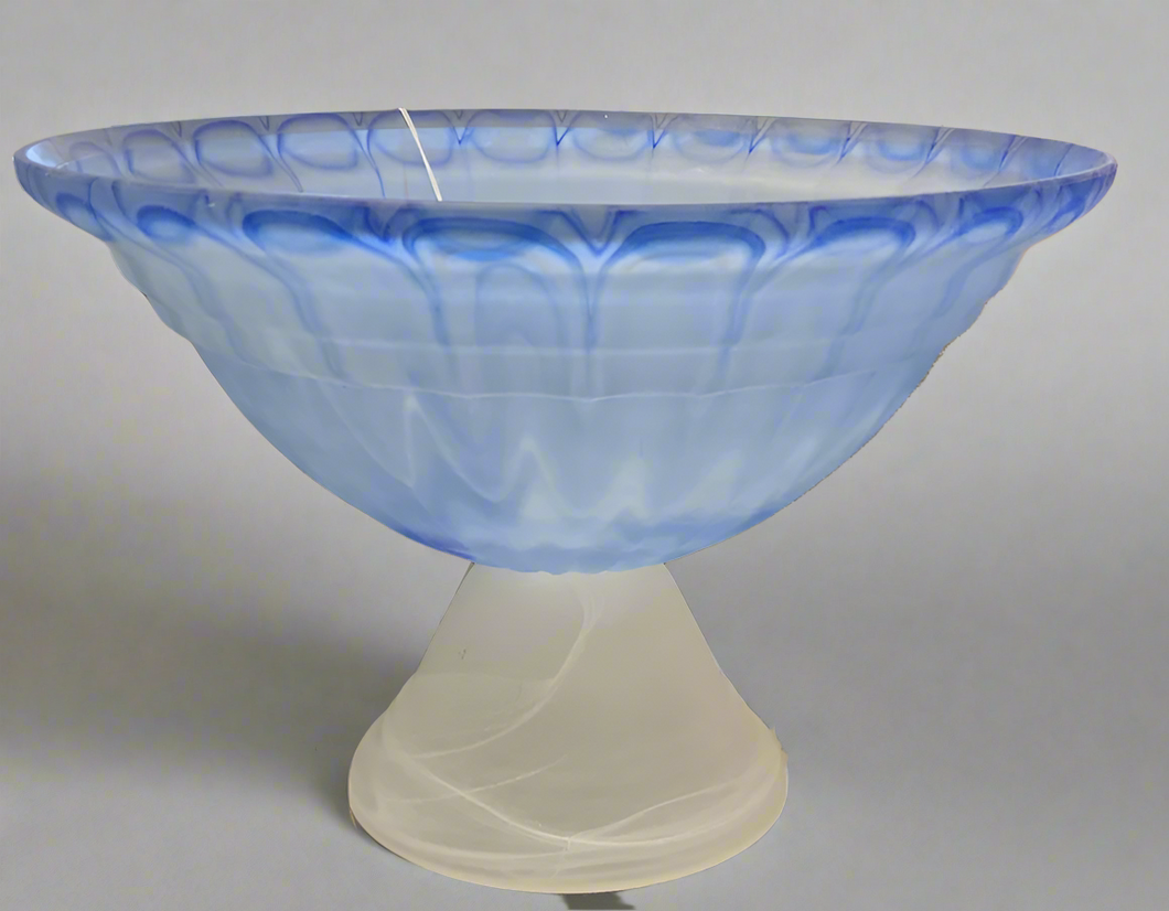 Decorative glass bowl with blue and white design on a reflective surface