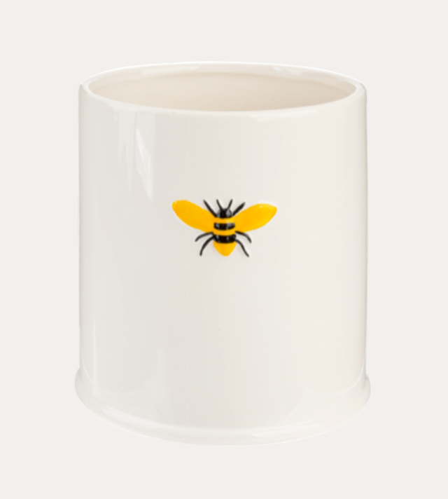White ceramic pot with a bee design on a white background