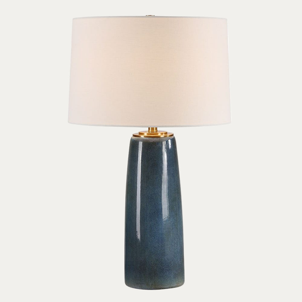 Table lamp with a blue ceramic base and white shade on a white background